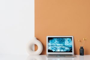 Minimalist workspace featuring a laptop with digital marketing text, a ceramic vase, and dried grass. — 5 Ways a Strong Backl