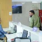 A receptionist assists a guest at the reception desk in a modern hotel lobby in Dhaka, Bangladesh. — Avoid Delays in Projects