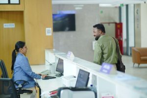 A receptionist assists a guest at the reception desk in a modern hotel lobby in Dhaka, Bangladesh. — Avoid Delays in Projects