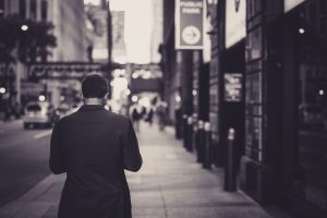 Man in a suit walking down a city street in a lonely, urban setting. — Choose a forex broker that offers fast execution and t
