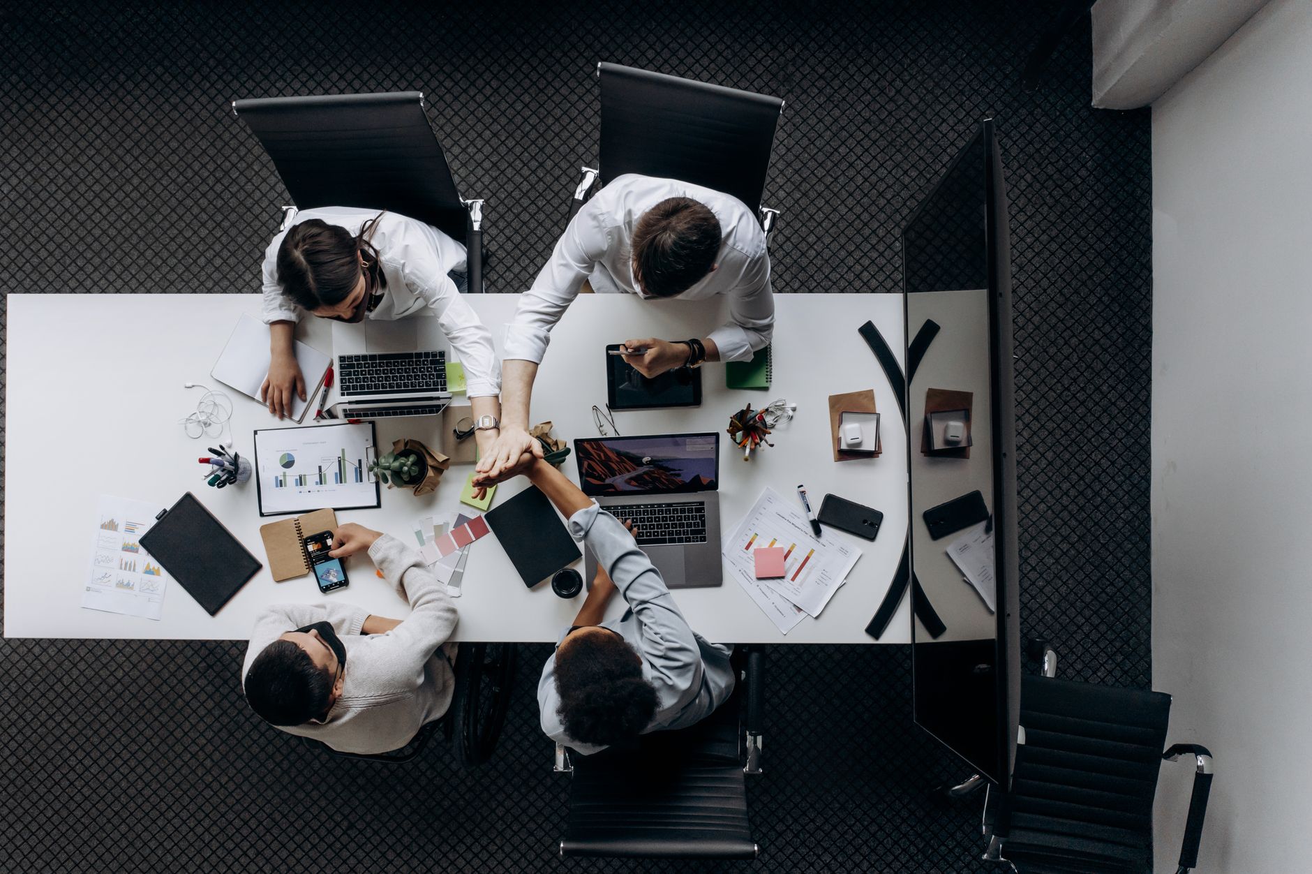 High angle view of colleagues collaborating around a conference table in a modern office setting. — Community Upliftment Thro