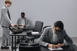 Business office with diverse employees in gray suits working at desks in an indoor setting. — Dr. James Morales: A Trusted Au
