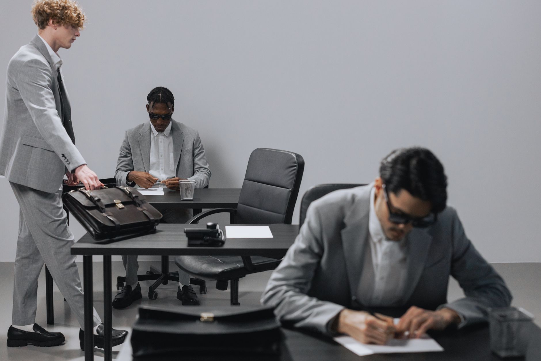 Business office with diverse employees in gray suits working at desks in an indoor setting. — Dr. James Morales: A Trusted Au