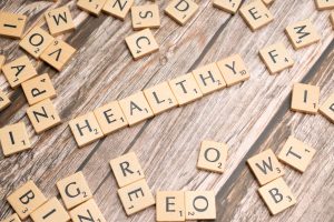 Wooden letter tiles arranged on a wooden surface spelling out 'healthy', symbolizing wellness. — Dr. Zachary Lipman Bridging