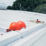 Red hard hats and safety equipment on a metal roof, emphasizing construction safety. — Pannelling Creates a Stylish and Timel