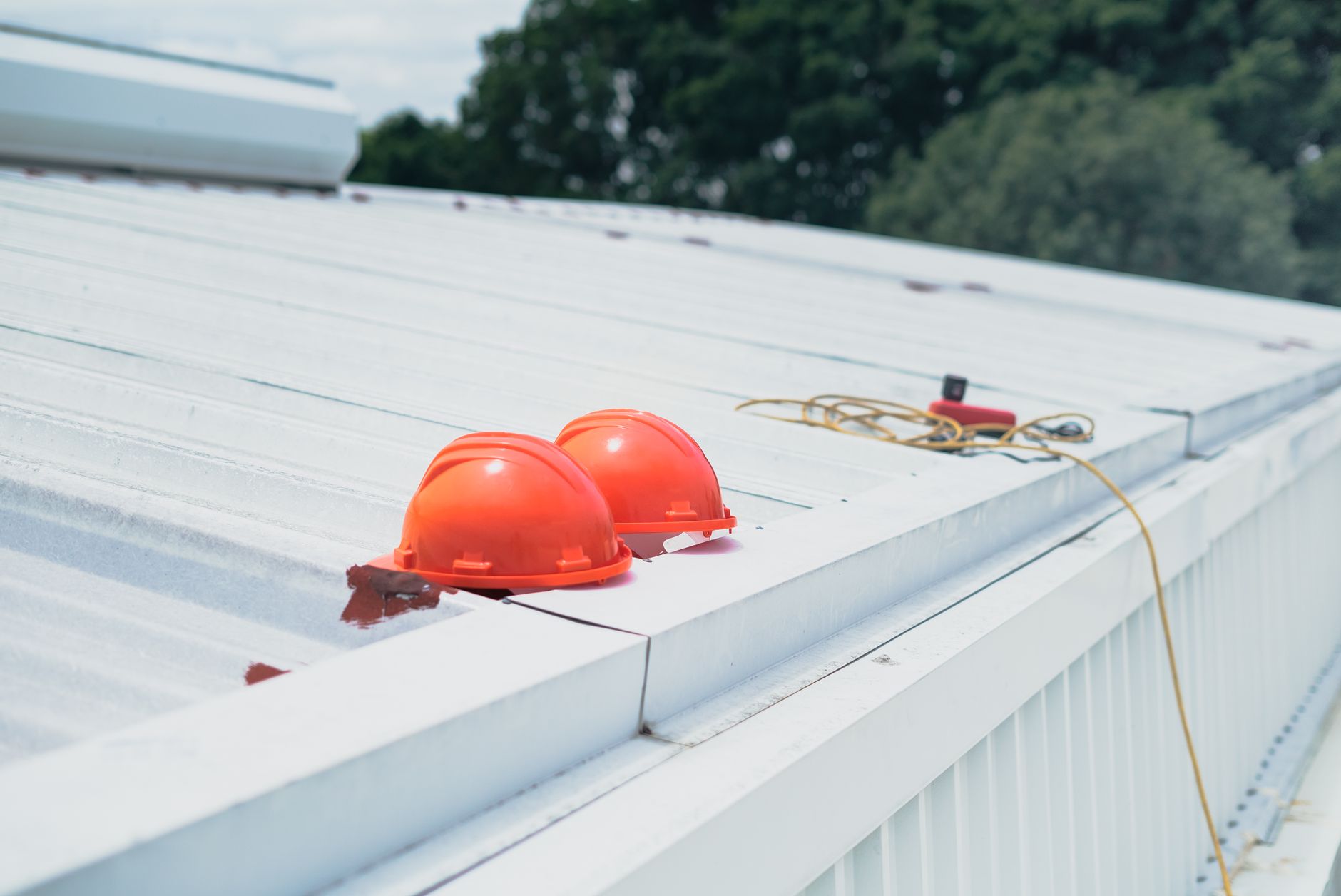 Red hard hats and safety equipment on a metal roof, emphasizing construction safety. — Pannelling Creates a Stylish and Timel