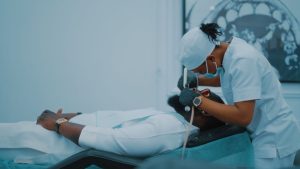 A dental professional performs a procedure on a patient in a Lagos clinic. — Purchase Testosterone Injections with Medical Gu