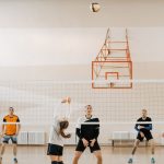 Adults playing an intense indoor volleyball game. Perfect depiction of sportsmanship and teamwork. — Real Valladolid CF's Com