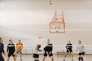 Adults playing an intense indoor volleyball game. Perfect depiction of sportsmanship and teamwork. — Real Valladolid CF's Com