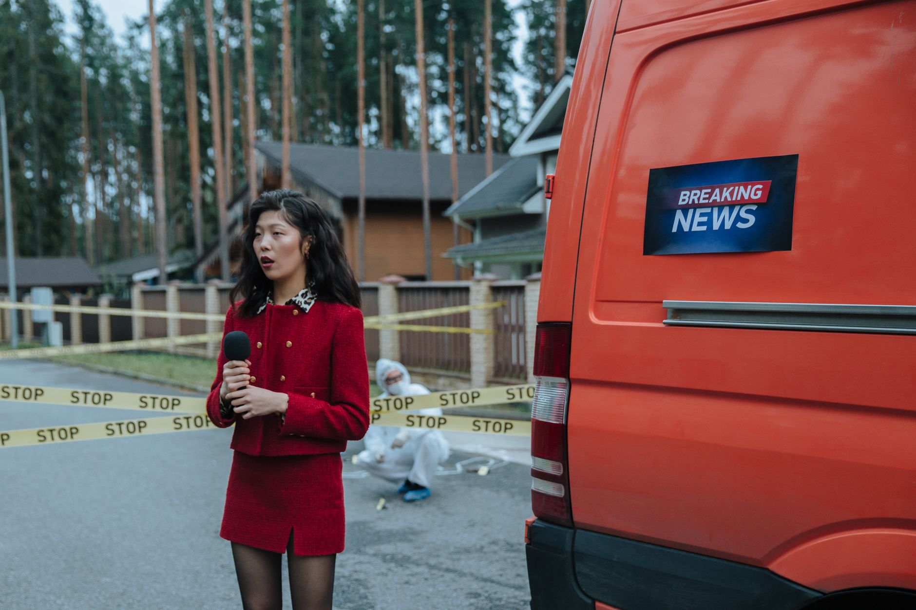 Female reporter in red outfit at an outdoor crime scene with warning tape and a news van. — The Path to Instagram Stardom: Bu