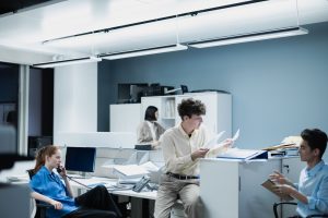 Office team collaborating with documents in a modern workspace, focusing on teamwork and productivity. — Trade with Confidenc