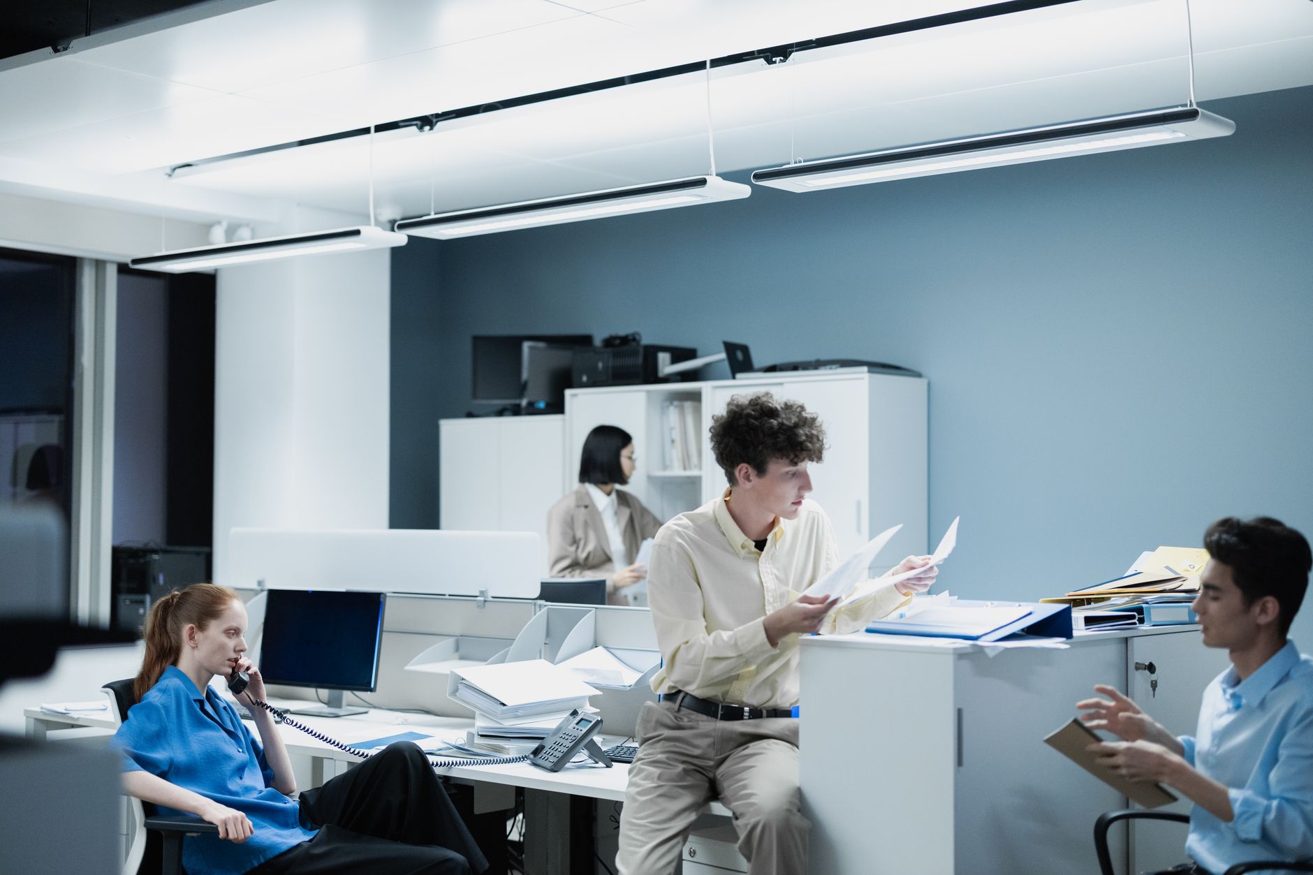 Office team collaborating with documents in a modern workspace, focusing on teamwork and productivity. — Trade with Confidenc