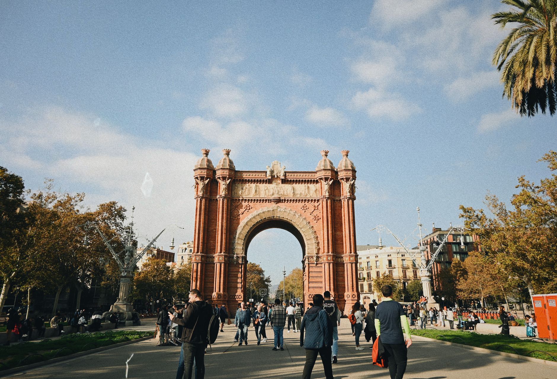 People walking near Arc de Triomf in Barcelona with clear skies overhead. — Walking with Legends Gokyo and EBC with Sherpa Gu