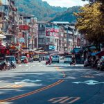 Vibrant urban street scene with shops, vehicles, and mountains in an Asian city. — Why a Well-Structured Eviction Notice Main
