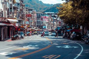 Vibrant urban street scene with shops, vehicles, and mountains in an Asian city. — Why a Well-Structured Eviction Notice Main